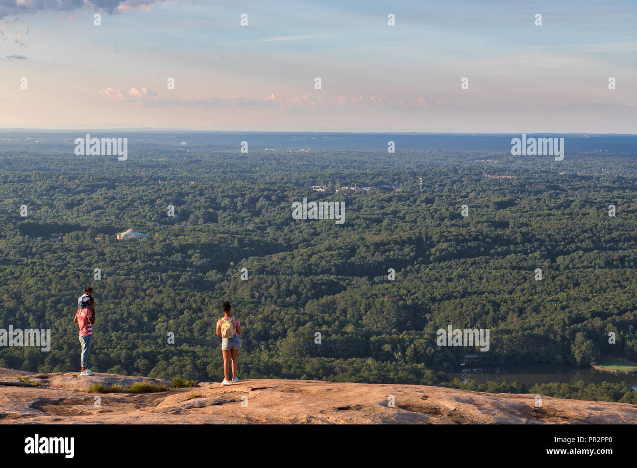 Nicht identifizierbare Personen mit Blick auf das Grün der Bäume, Wälder und Wasser von oben von Stone Mountain in Georgia an einem schönen Sommer Tag sichtbar Stockfoto