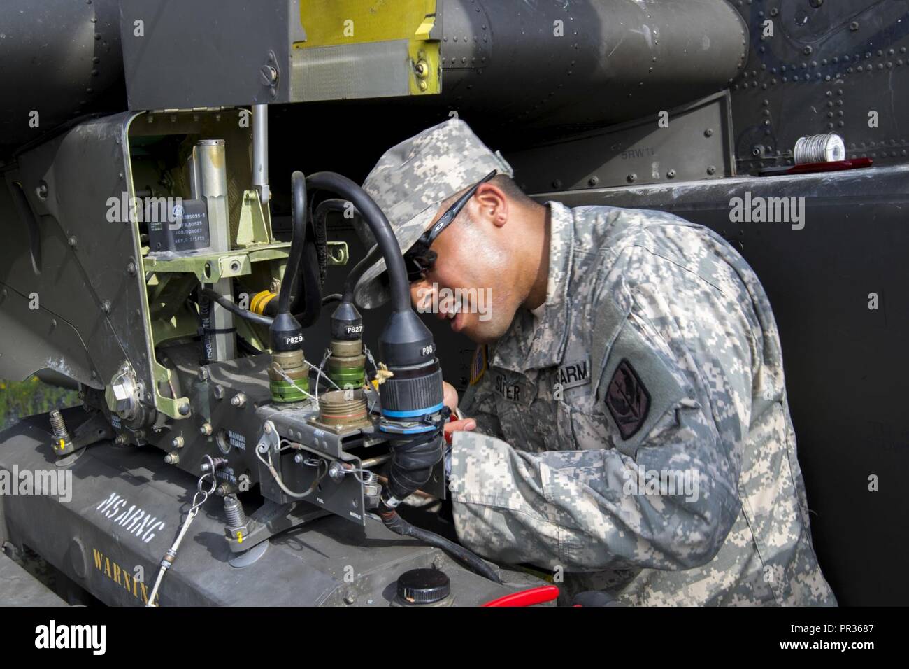 Spc. Kourtland Slater, mit 1St Bataillon, 130 Luftfahrt, North Carolina Army National Guard, passt die Waffen Auswurf kostenlos auf einem AH-64D Apache Kampfhubschrauber am Joint Readiness Training Center, Fort Polk, Louisiana, 22. Juli 2017. Stockfoto