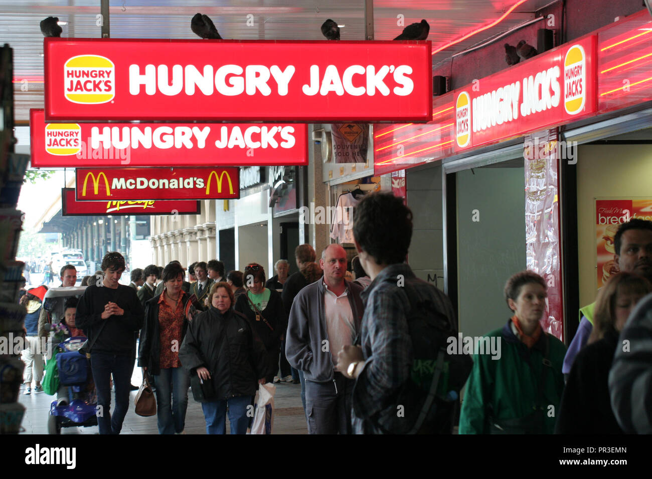Menschenmassen Spaziergang unter Hungry Jacks UND MCDONALD'S ZEICHEN IN die Swanston Street, Melbourne, Victoria, Australien Stockfoto