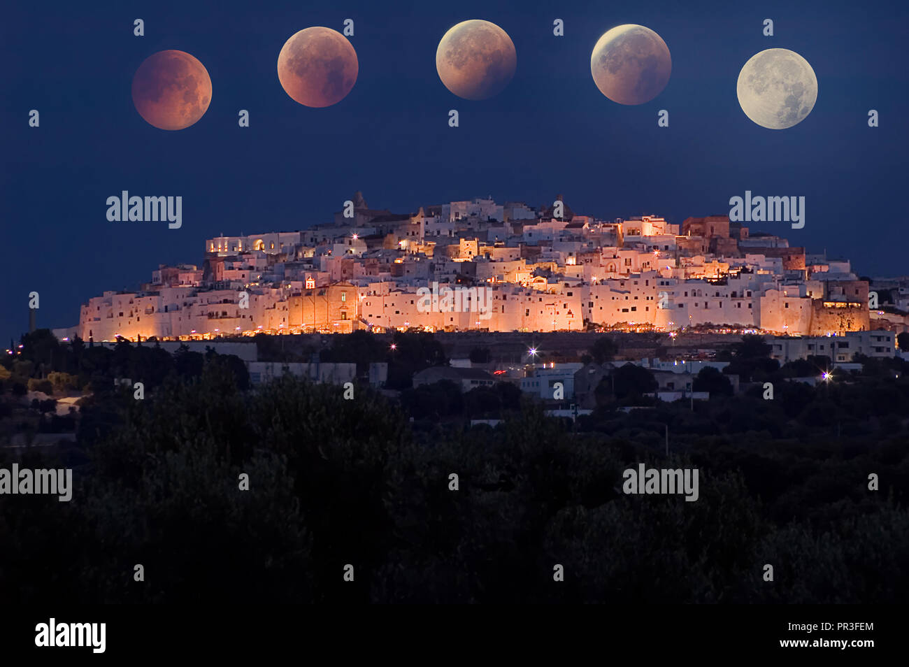 Ostuni in der Nacht, die weiße Stadt in Apulien, mit Total Eclipse Stockfoto