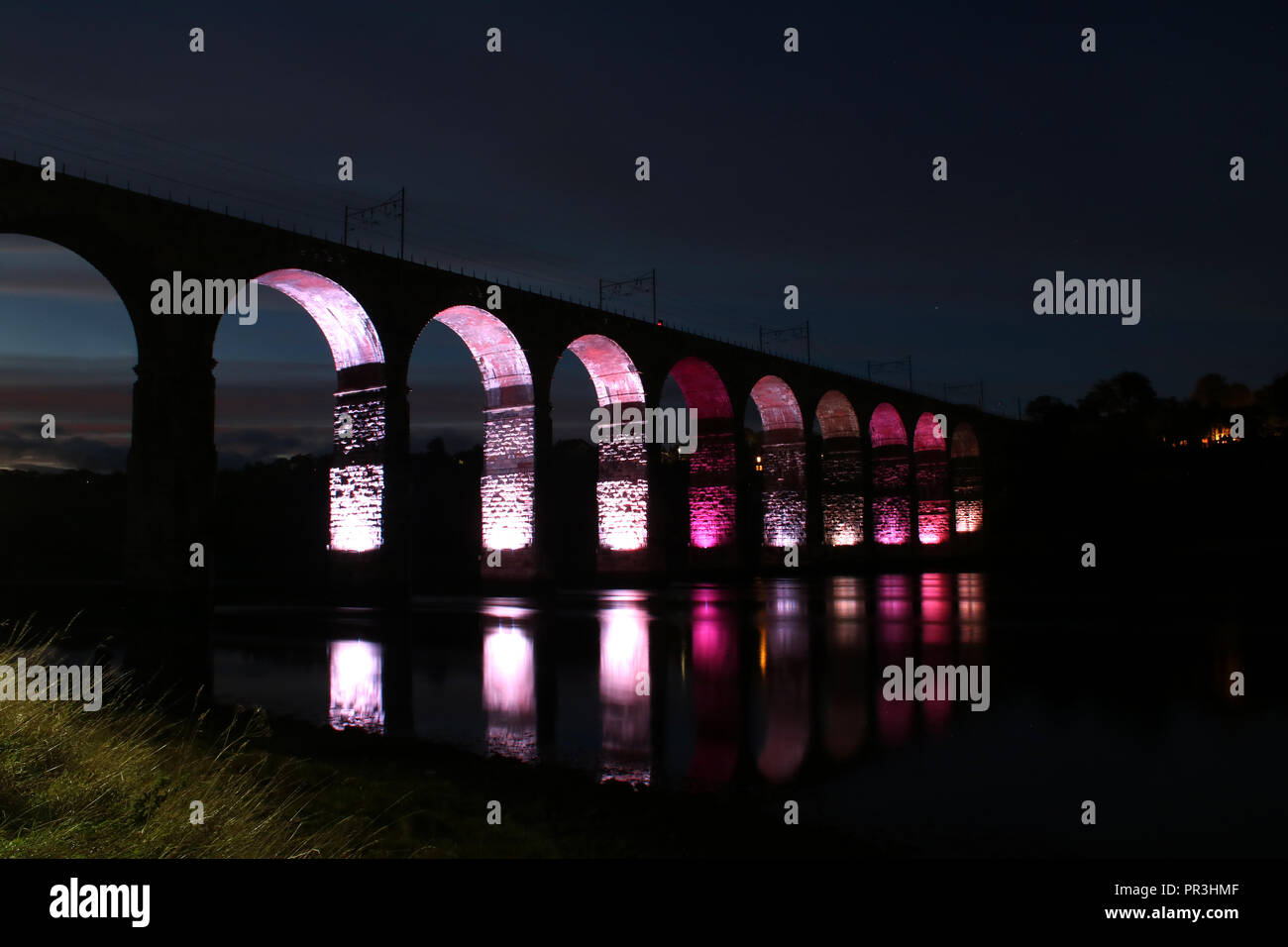 Royal Border Bridge auf der East Coast Main Line über den Fluss Tweed beleuchteten Bögen und Reflexionen im Wasser unten in Berwick-upon-Tweed, Großbritannien Stockfoto