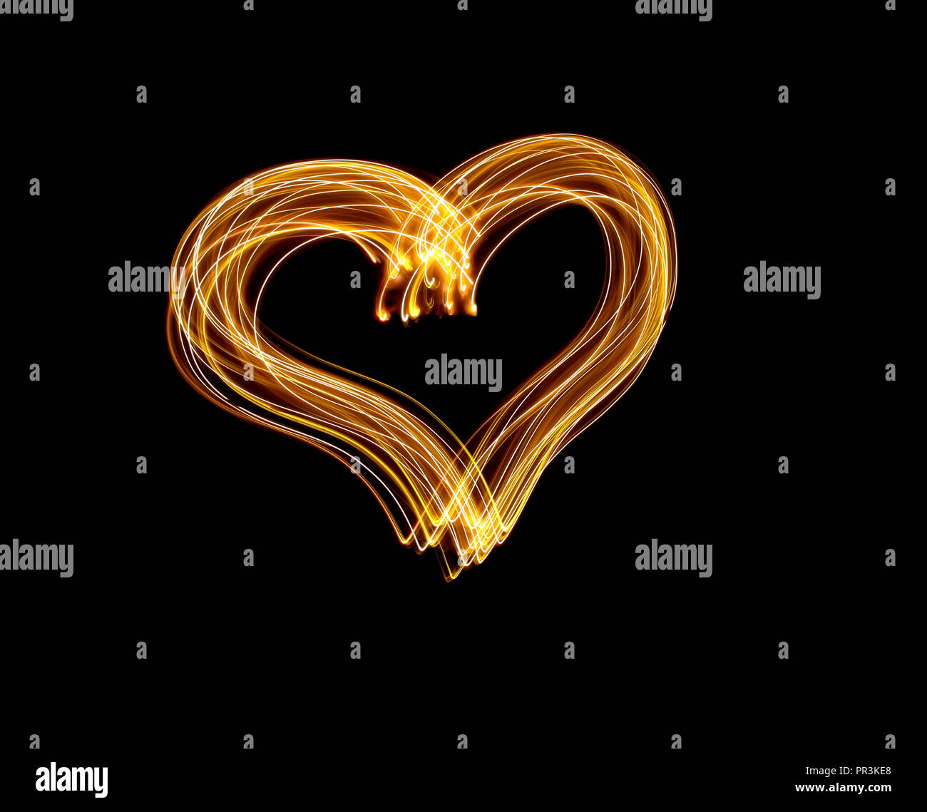 Lange Belichtung Licht Malerei Fotografie, Form eines Herzens Umrisse, vibrant Neon metallic gelb gold auf schwarzem Hintergrund Stockfoto