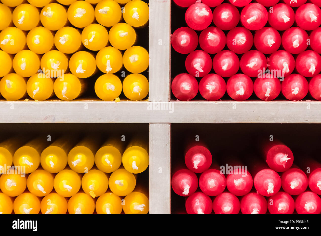 Rot und Gelb paraffin stick Kerzen auf Regalen in einem Shop angeordnet Stockfoto