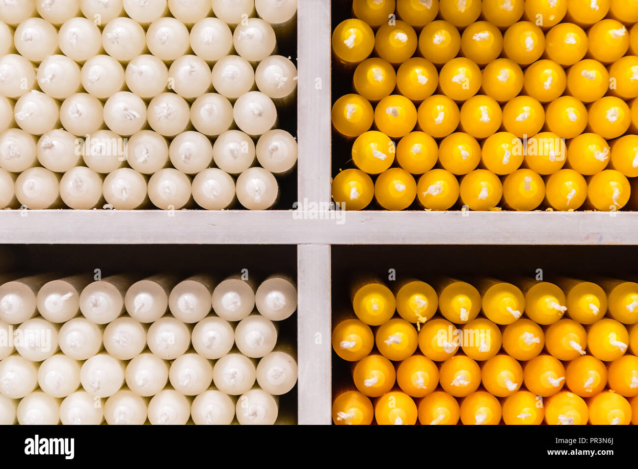 Weiß und Gelb paraffin stick Kerzen auf Regalen in einem Shop angeordnet Stockfoto