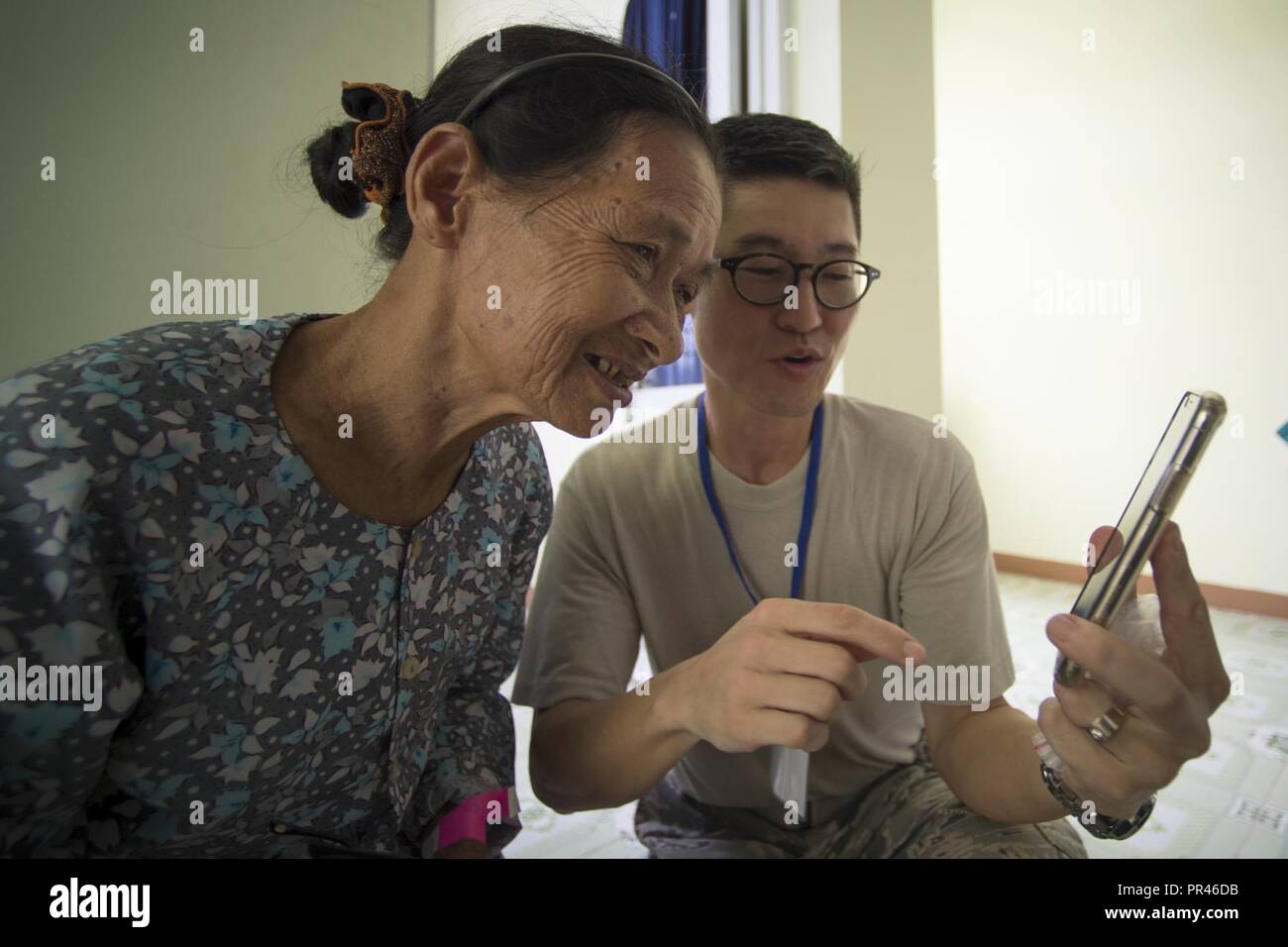 Us Air Force Maj. John Kim (rechts), 36. Medizinische Maßnahmen Squadron Optiker, zeigt Luong Thi Nhim, ein Foto mit Ihrer neuen Brille während der Pacific Engel (PACANGEL) 18-2 im Kulturzentrum Haus der Tam Giang Gemeinde im Nui Thanh, Quang Nam Provinz, Vietnam, Sept. 10, 2018. Kim, ein Eingeborener von Paramount, Kalifornien, ist in Vietnam die Teilnahme an PAC ENGEL 18-2, eine multilaterale humanitäre Hilfe zivil-militärische Engagement, die militärische Partnerschaften im Indopazifik verbessert und gleichzeitig Medical Health Outreach, Civic Engineering Projekte und das Thema Austausch bin Stockfoto