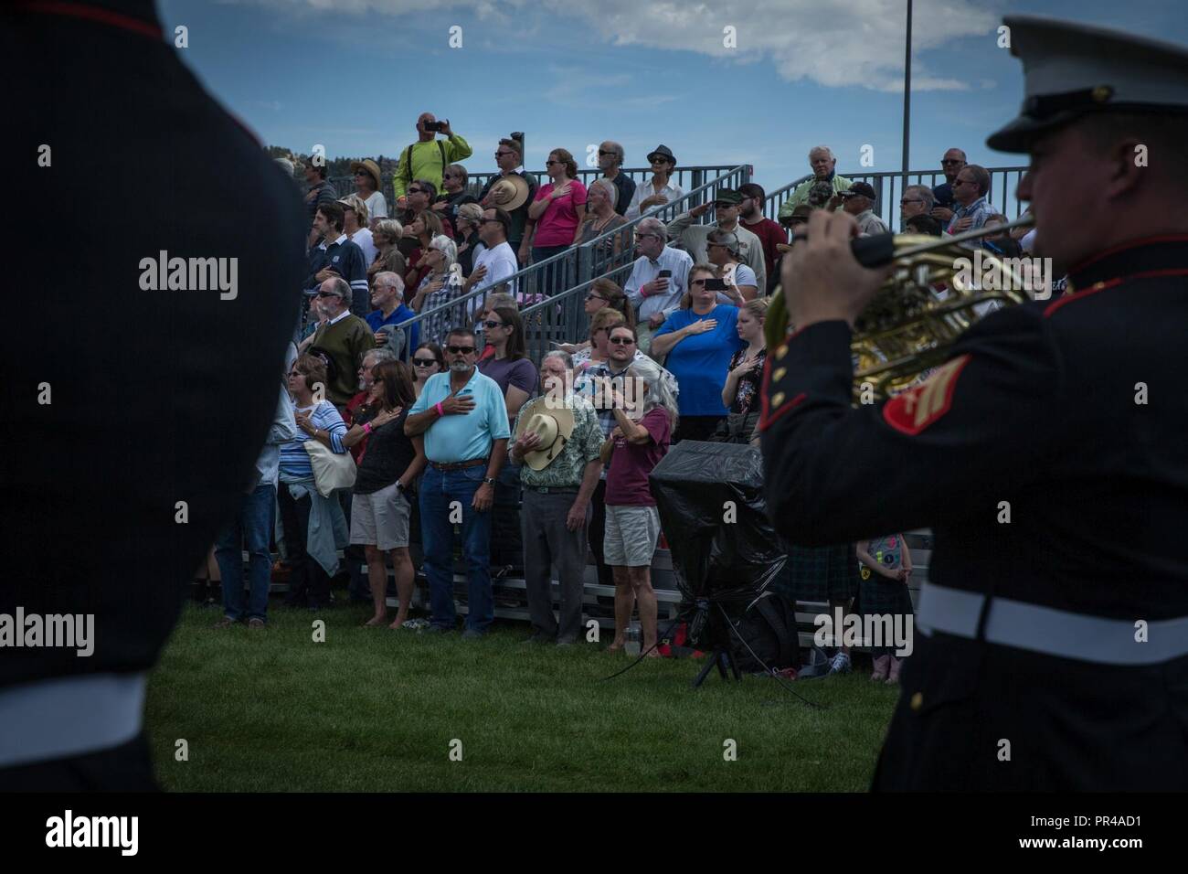 Das Publikum steht für die Nationalhymne während der Eröffnung der 42. jährlichen Longs Peak Highland Festival in Estes Park, Colorado, Sept. 7, 2018. Das Festival feiert Schottische und irische Erbe durch eine Vielzahl von traditionellen sportliche Spiele, ritterspiele Wettbewerbe, Musik und Tanz. Stockfoto