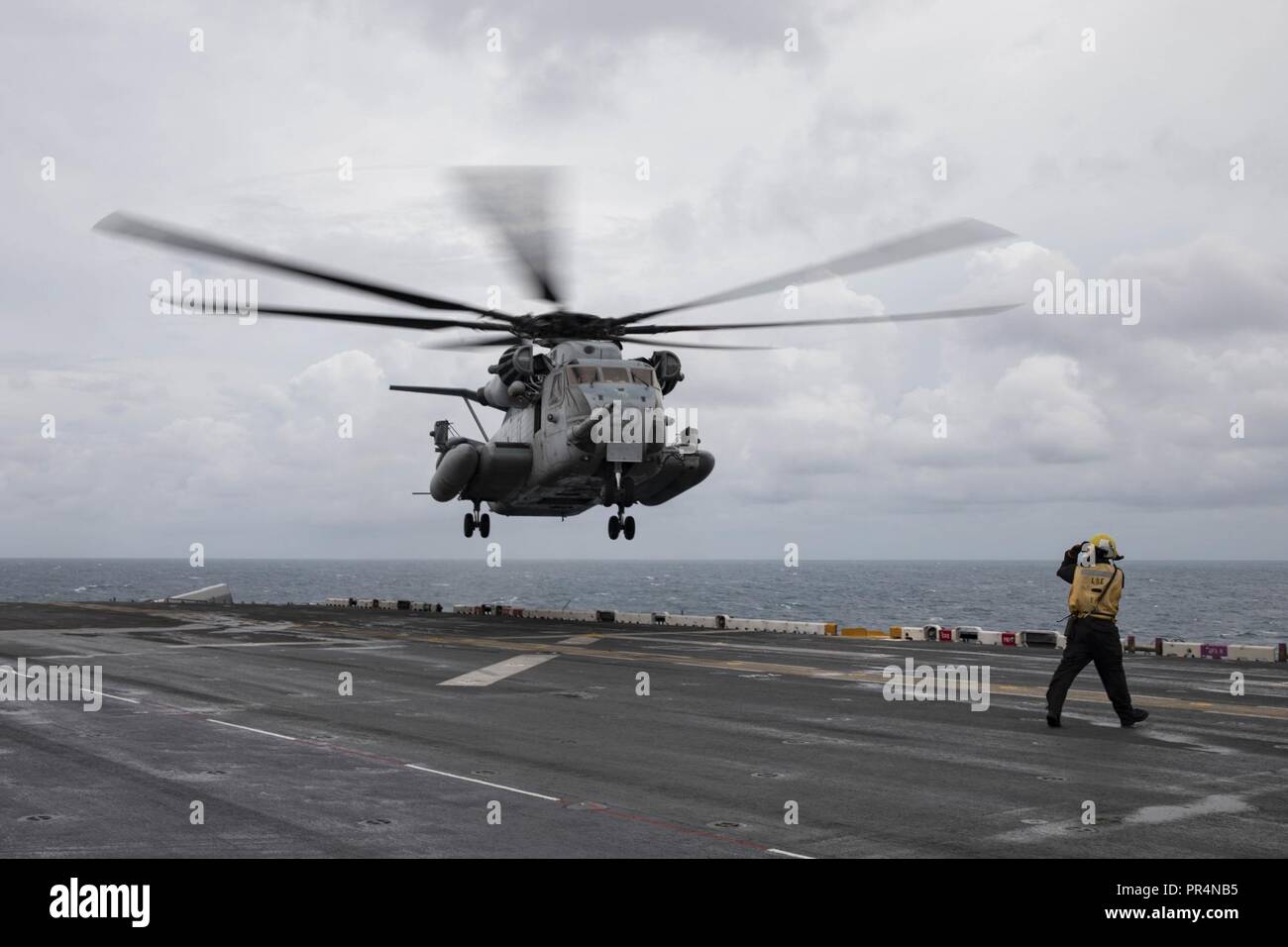 Atlantischer Ozean (Sept. 16, 2018) der Luftfahrt Bootsmann Mate (Handling) 3. Klasse Johnithan Bush Signale der Pilot einer CH-53E Super Stallion wie es landet auf dem Flugdeck des Wasp-Klasse amphibisches Schiff USS Kearsarge (LHD3). Us Naval Forces Northern Command eingesetzt Kearsarge, zusammen mit Eingeschifft Elemente der 22 Marine Expeditionary Unit und die Expeditionary Strike Group 2 Befehl Element positioniert werden kann, dass die zivilen Behörden Verteidigung Unterstützung aus dem Meer in Reaktion auf den Hurrikan Florenz bieten, sollten Unterstützung angefordert werden. Stockfoto