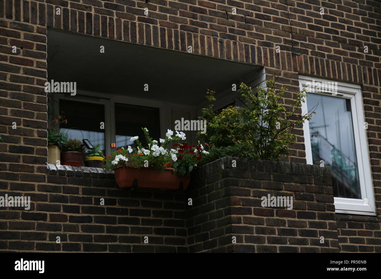 Balkon in einer Seitenstraße in Europa mit bunten Blumen Stockfoto