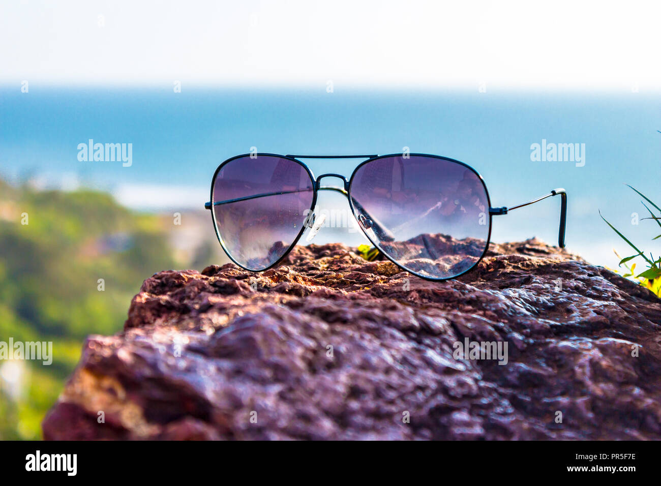 North Goa, Goa/Indien - 10. September 2018: Sonnenbrille im Fokus und Vagator Beach im Hintergrund. Stockfoto