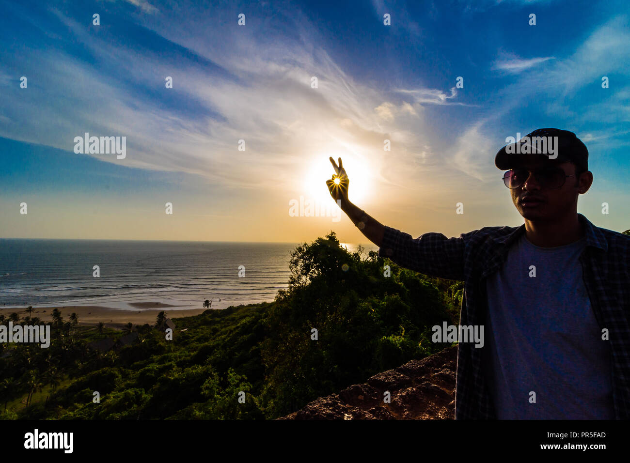 Vagator Beach - Sonnenuntergang Strahlen in den Rahmen um die Grüne natürliche Schönheit von Goa, Indien erfasst. Stockfoto