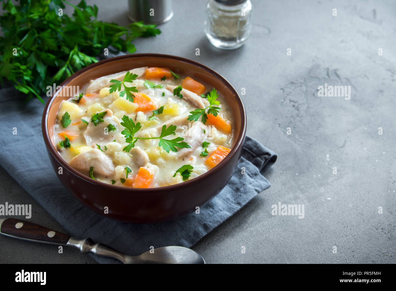 Huhn und wilder Reis Suppe. Hausgemachte frische cremige Suppe mit Hähnchen, Gemüse und Wildreis in weiße Schüssel. Stockfoto