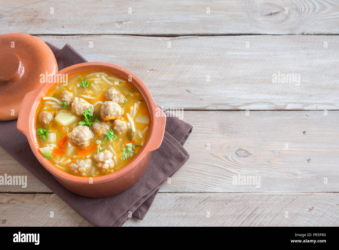 Frikadelle Suppe mit Gemüse und Nudeln über Holz- Hintergrund mit kopieren. Hausgemachte frikadelle Suppe. Stockfoto