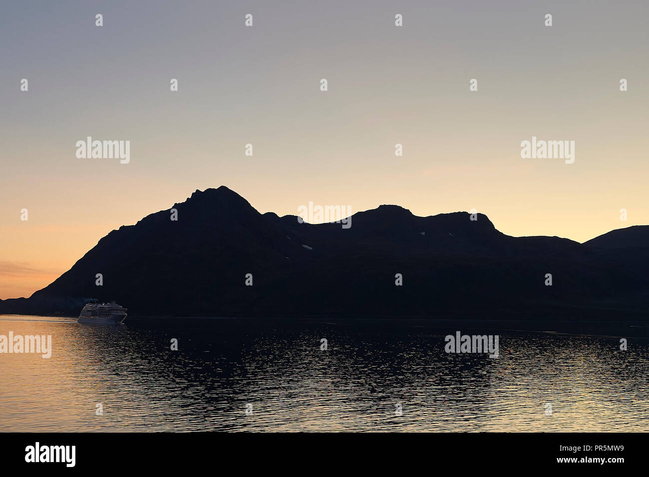 Das Kreuzfahrtschiff, Seabourn Ovation, Segel durch die Lauksundet, in der Nähe von Skjervøy, nördlich des Norwegischen Polarkreises bei Sonnenuntergang. Stockfoto