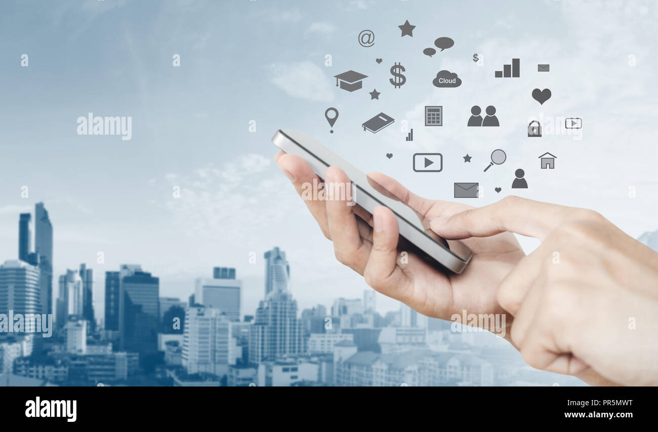 Handy Anwendung und Technologie. Hand mit Smart Phone und Stadt Hintergrund Stockfoto