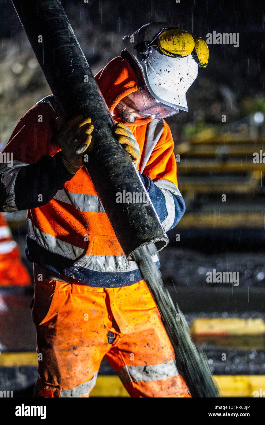 Eisenbahn Bauarbeiter Zement in der Nacht gießen Stockfoto