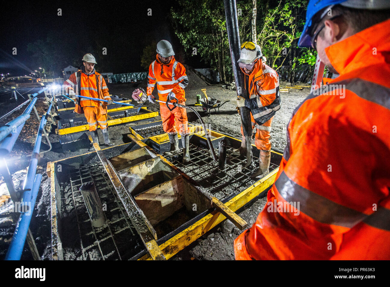 Eisenbahn Bauarbeiter Zement in der Nacht gießen Stockfoto