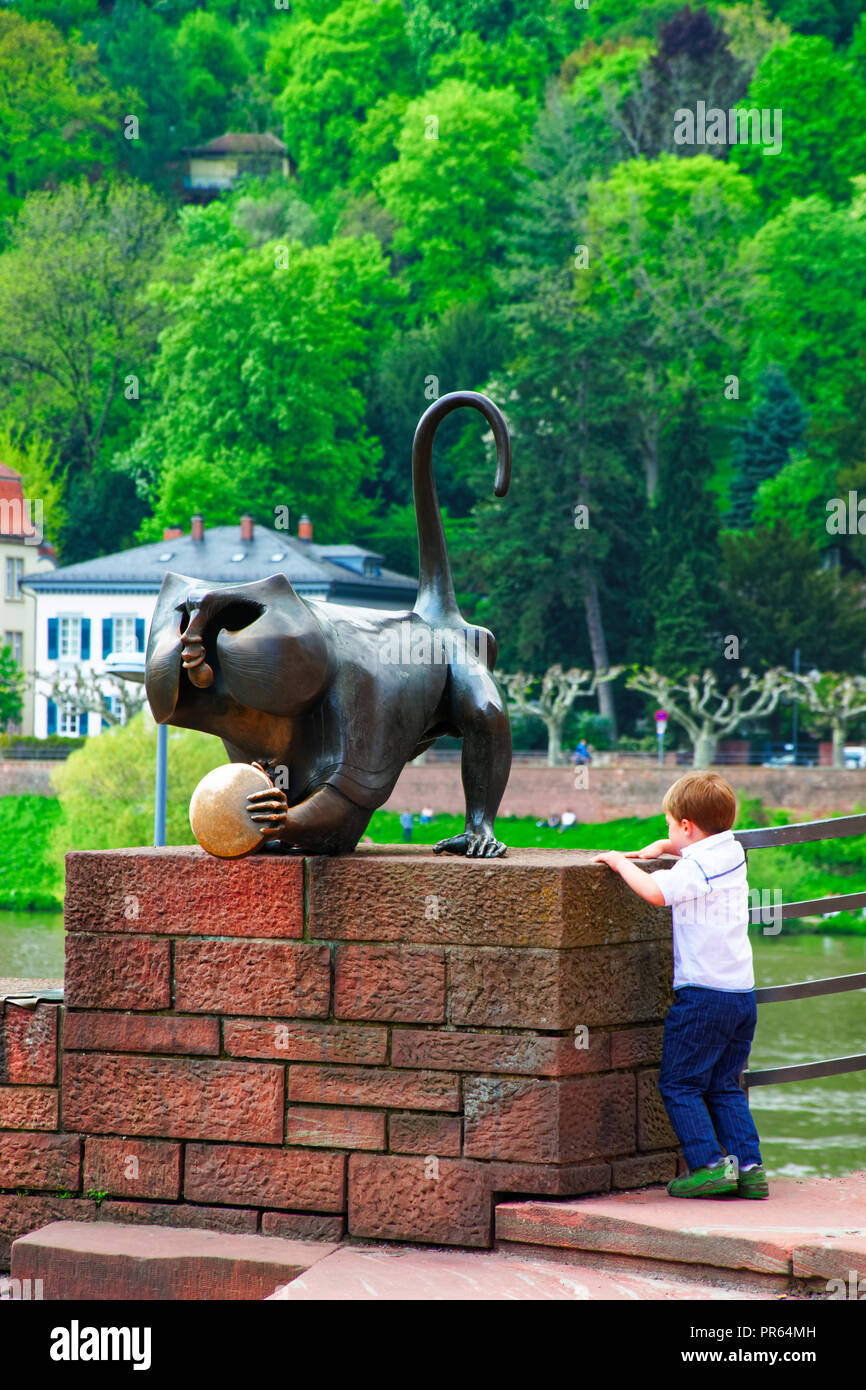 Heidelberg, Deutschland - Mai 5, 2013: Junge spielt in Bronze Monkey Statue auf der Brücke im Sommer Heidelberg, Deutschland Stockfoto