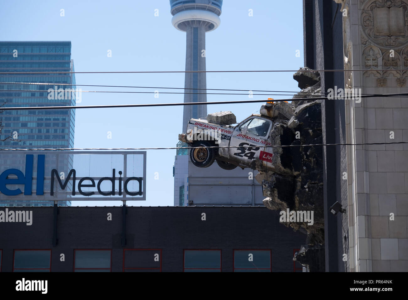 Ein Stück der Street Art der Darstellung einen Nachrichten Fahrzeug platzen aus der Wand der Glocke Medien HQ in der Innenstadt von Toronto Stockfoto