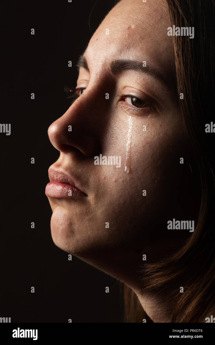 Trauriges Mädchen mit pimply Haut weinend auf schwarzem Hintergrund closeup Portrait Stockfoto