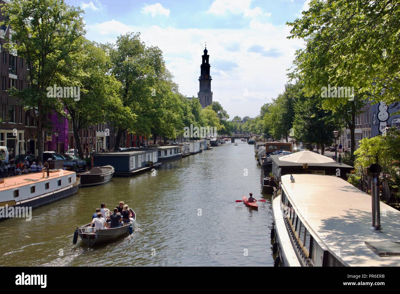 Drei verschiedene Arten von Booten: Motorboot, Canal House Boot und Kajak auf einer Gracht in Amsterdam an einem Sommertag Stockfoto