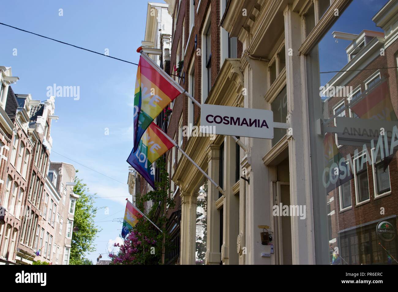 Regenbogenfahnen, die sagen: Liebe auf sie für Amsterdam Pride außerhalb Cosmania auf Herenstraat, Amsterdam Stockfoto