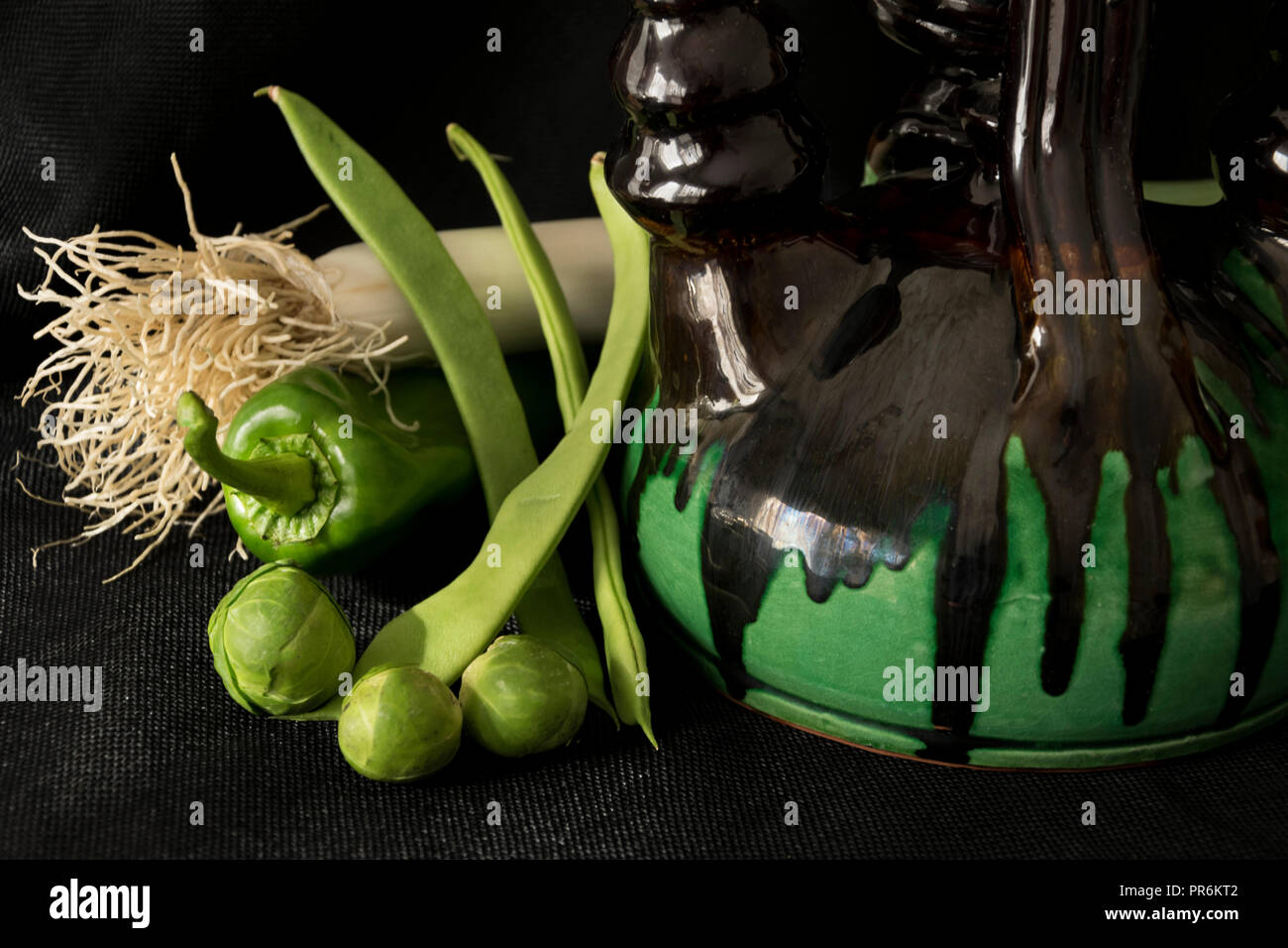 Gemüse neben einem dekorativen Krug bilden einen immer noch Leben. Stockfoto