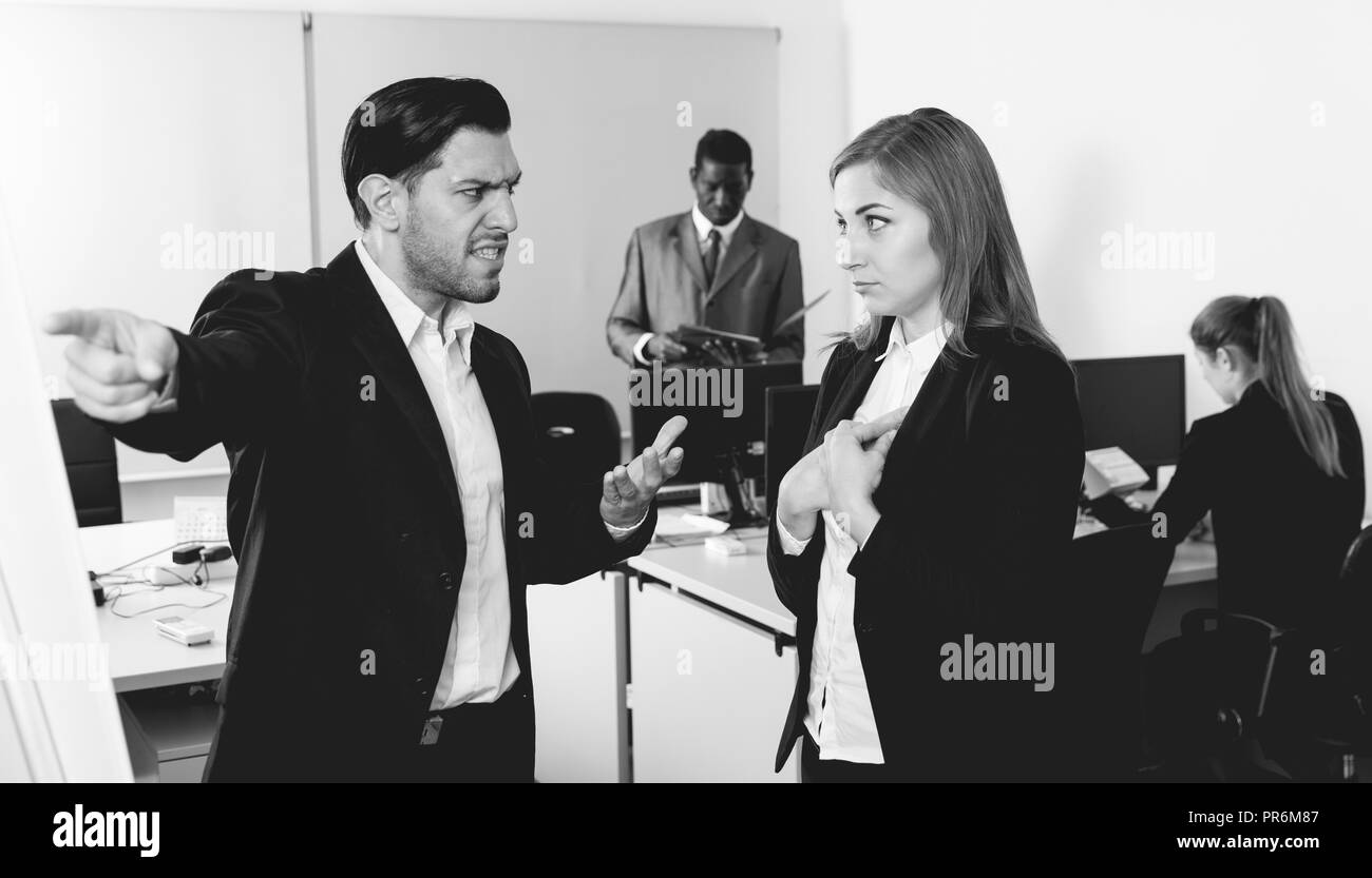 Angry Chef zeigt seine Hand an der Ausfahrt in modernen Büro und Entlassung beleidigt frustriert weiblichen Untergebenen Stockfoto