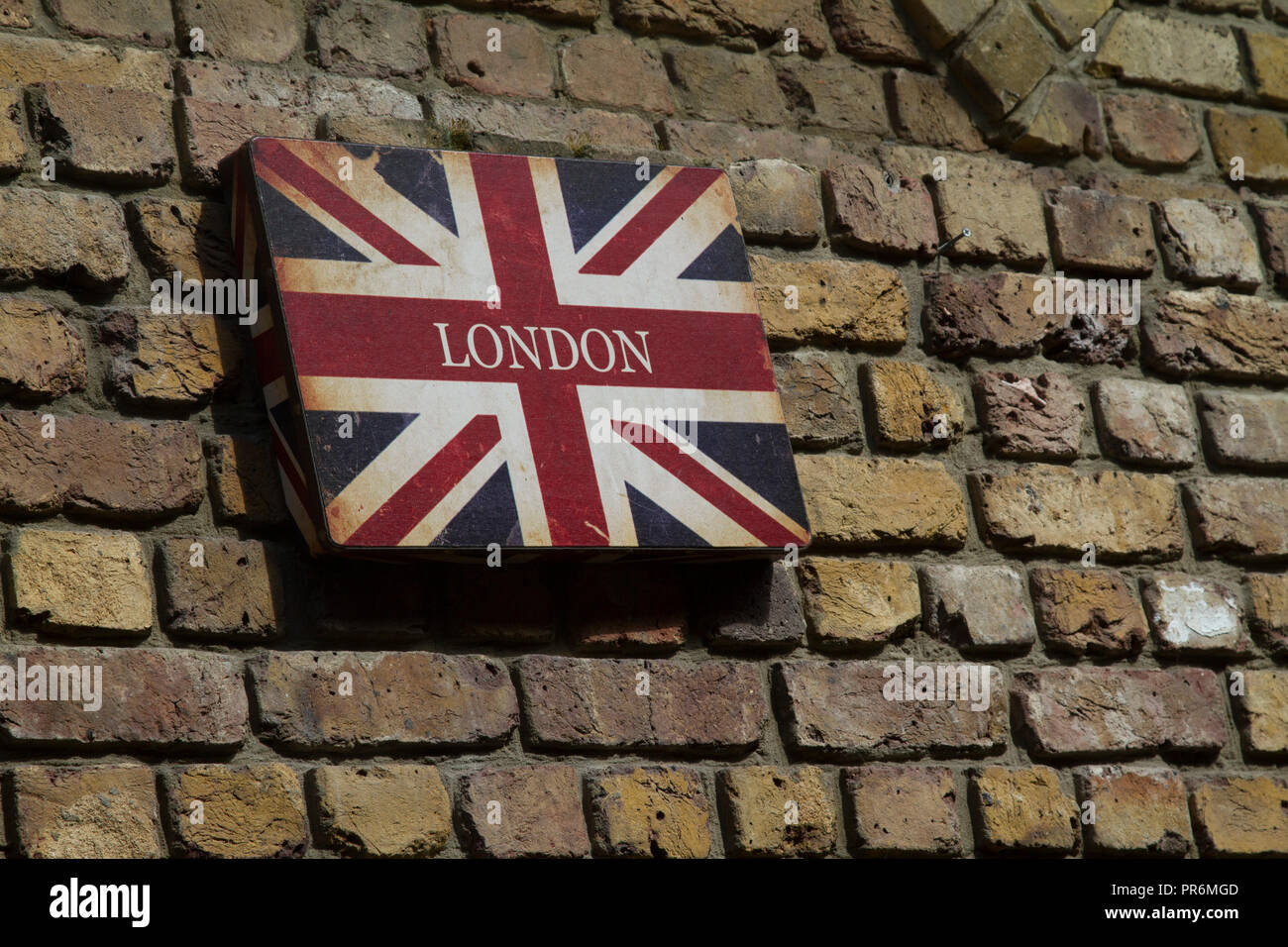 Union Jack Flagge, Lager das Wort London, auf eine Mauer aus Stein Stockfoto