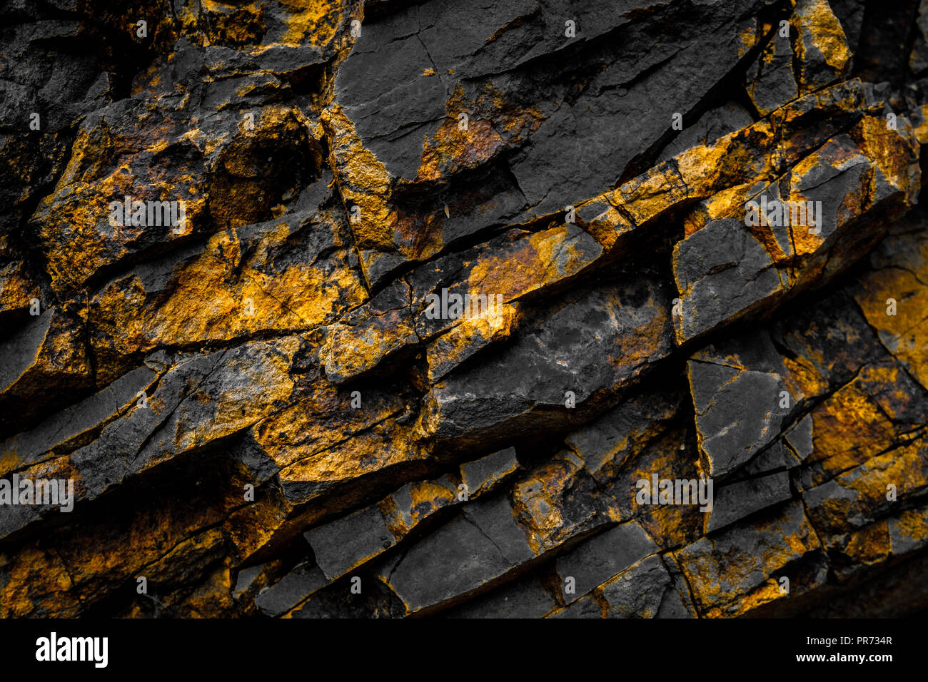Black Rock Hintergrund mit Gold/gelb gefärbte Felsen - Stockfoto