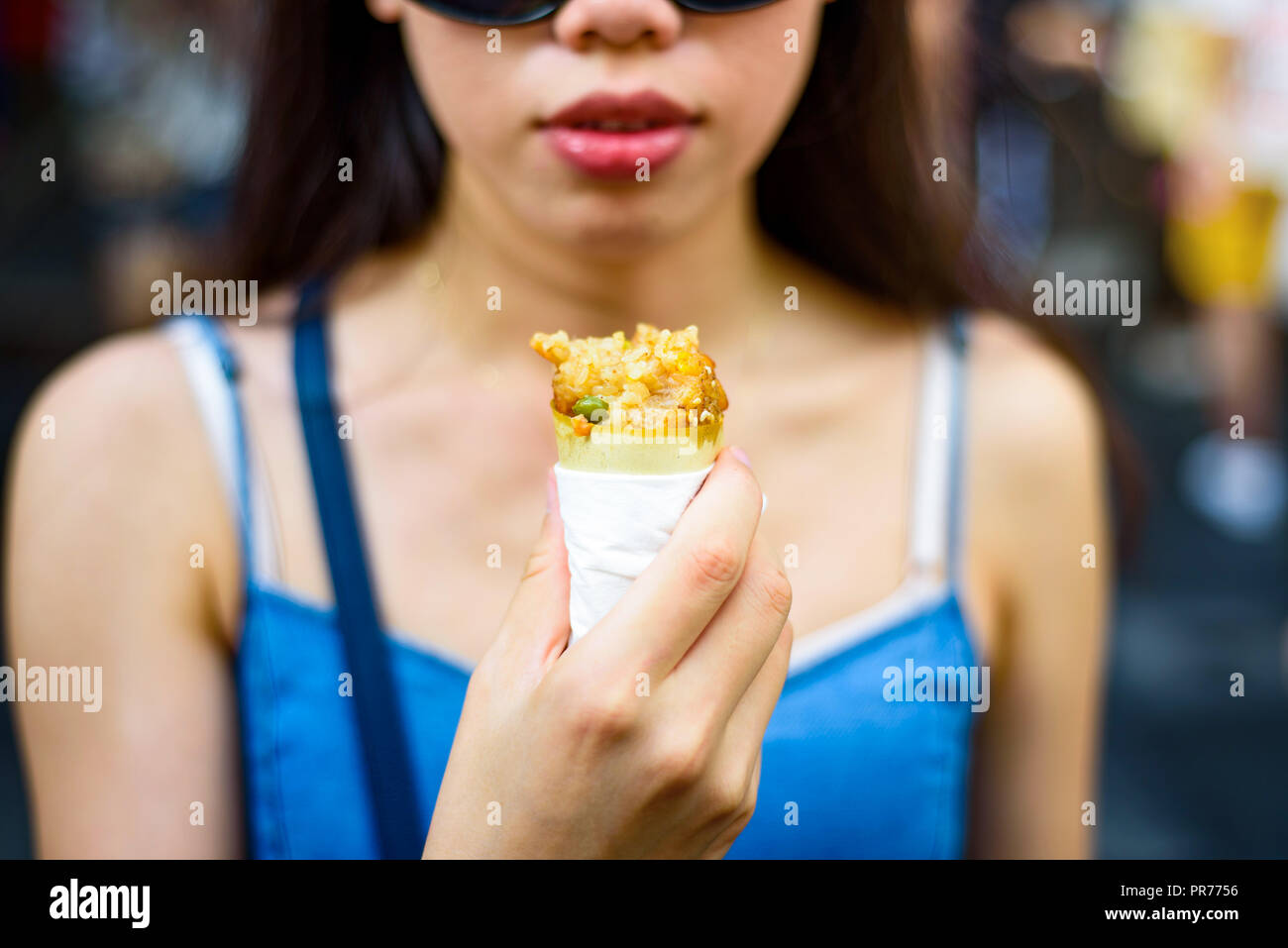 Mädchen essen Chicken Wing schnüffelte mit Reis auf der Straße Stockfoto