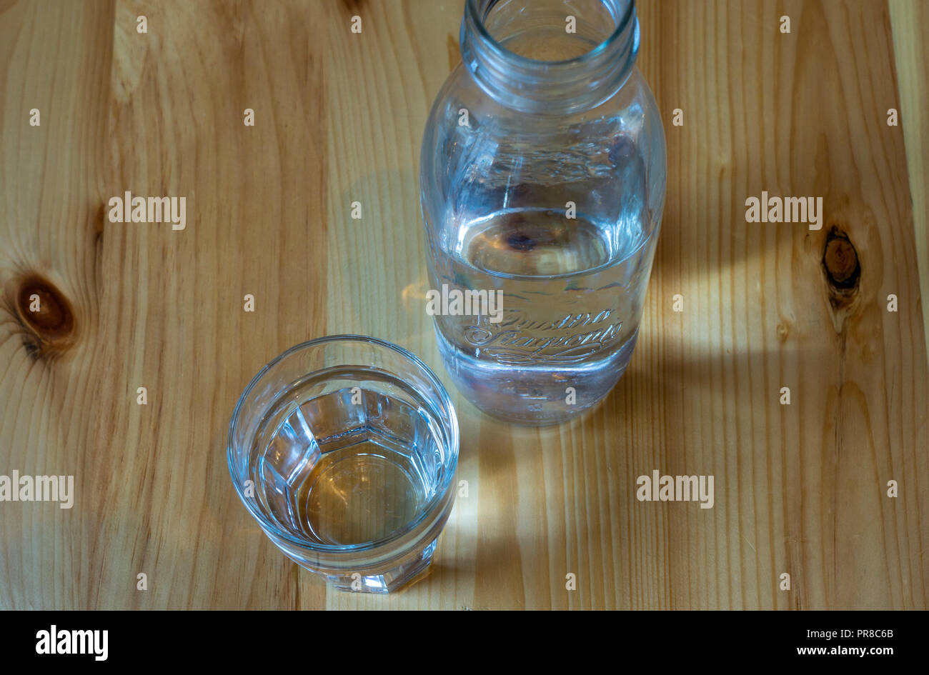 Eine Flasche und Glas auf einen hölzernen Tisch mit Wasser H2O Stockfoto