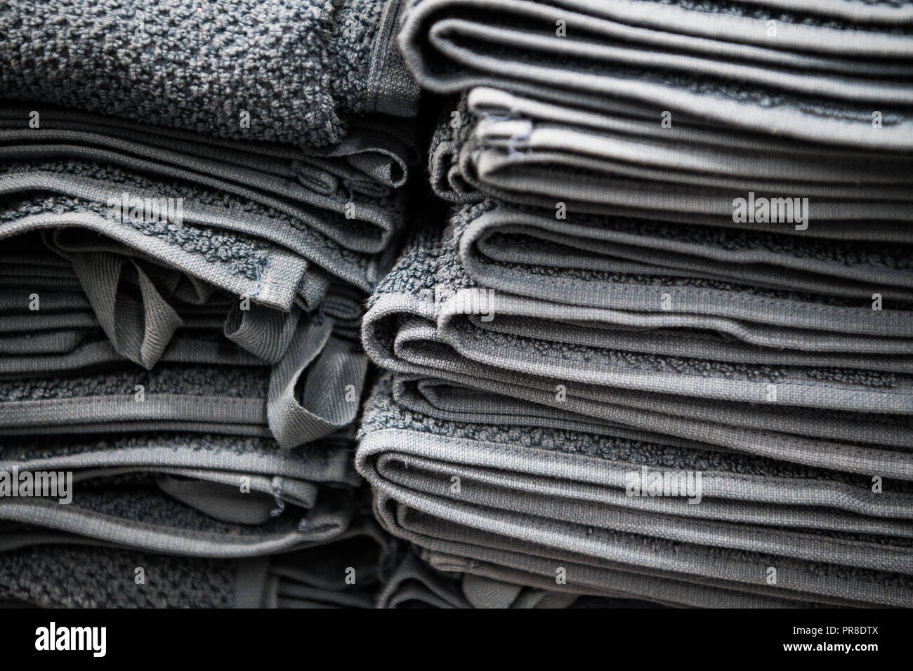 Natürliche reine Bettwäsche Handtücher, Servietten Tischdecke. Kleine Unternehmen. Stapel der gestreiften weiß grau Bettwäsche aus Baumwolle auf Stoff Hintergrund. Essen foto Requisiten Stockfoto
