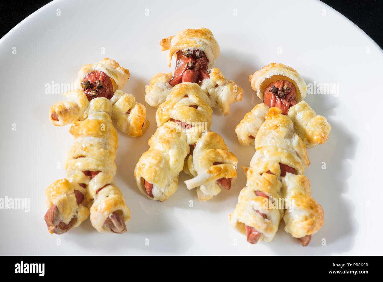 Halloween Essen. Wurst Mumien in der Teig in den Ofen gekocht Stockfoto