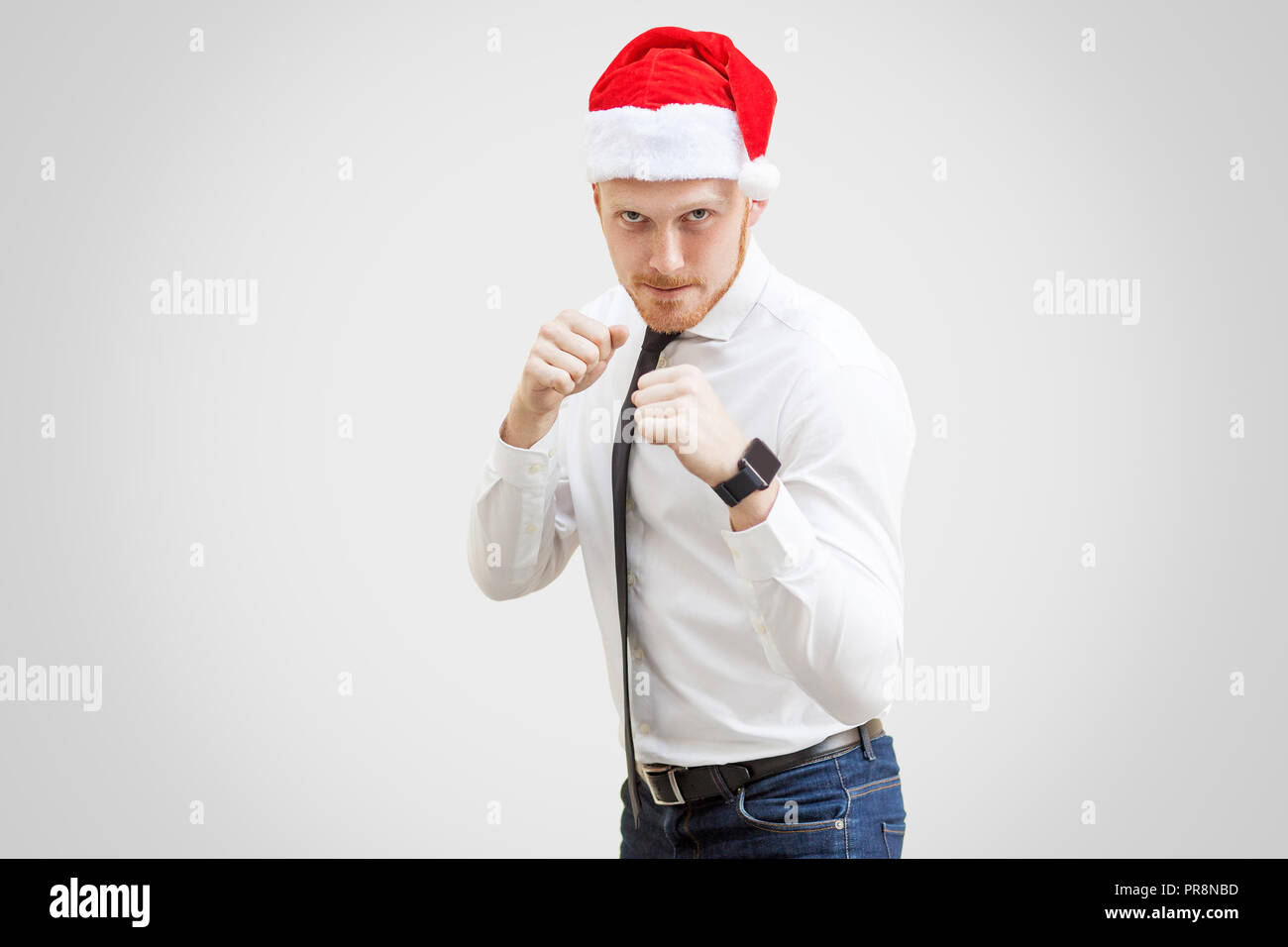 Portrait von aggressiven gut aussehender Geschäftsmann in weißem Hemd, schwarzer Krawatte und Rot das neue Jahr hat, an der Kamera, mit dem Boxen Faust und die Pflege von ernstes Gesicht. Stockfoto