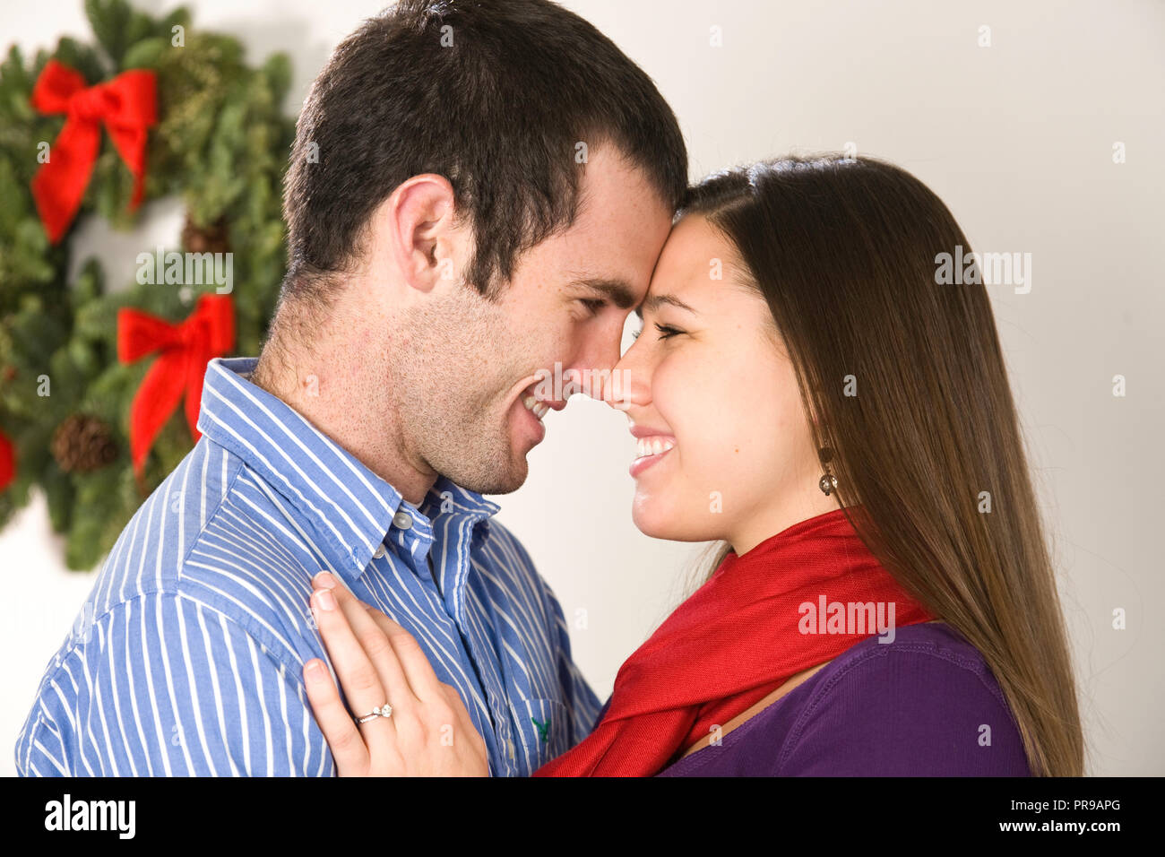 Liebevolle junge Paar Sharing a Christmas moment, USA Stockfoto
