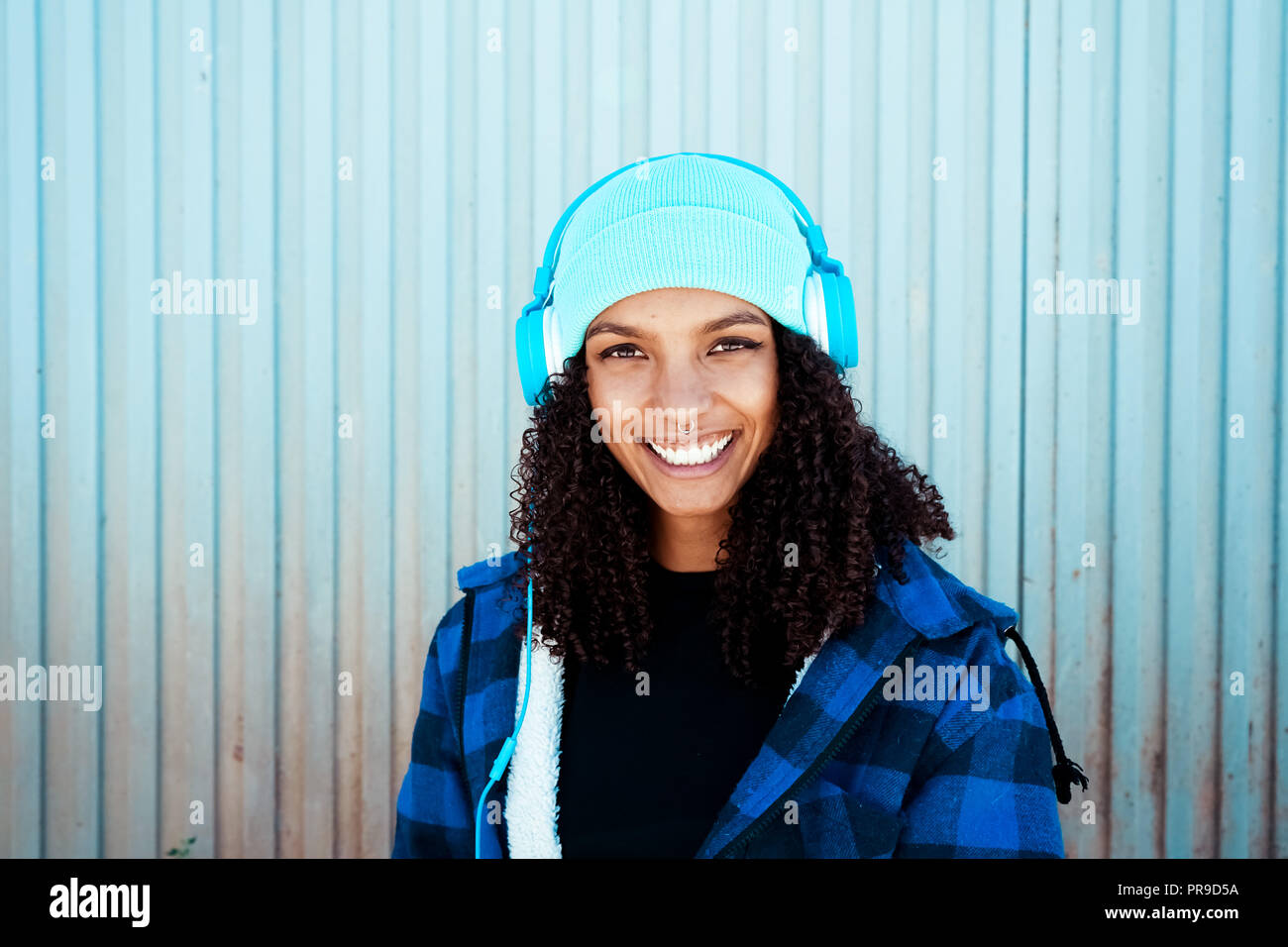 Junge Teenager Frau Musik vor einer blauen Wand Stockfoto