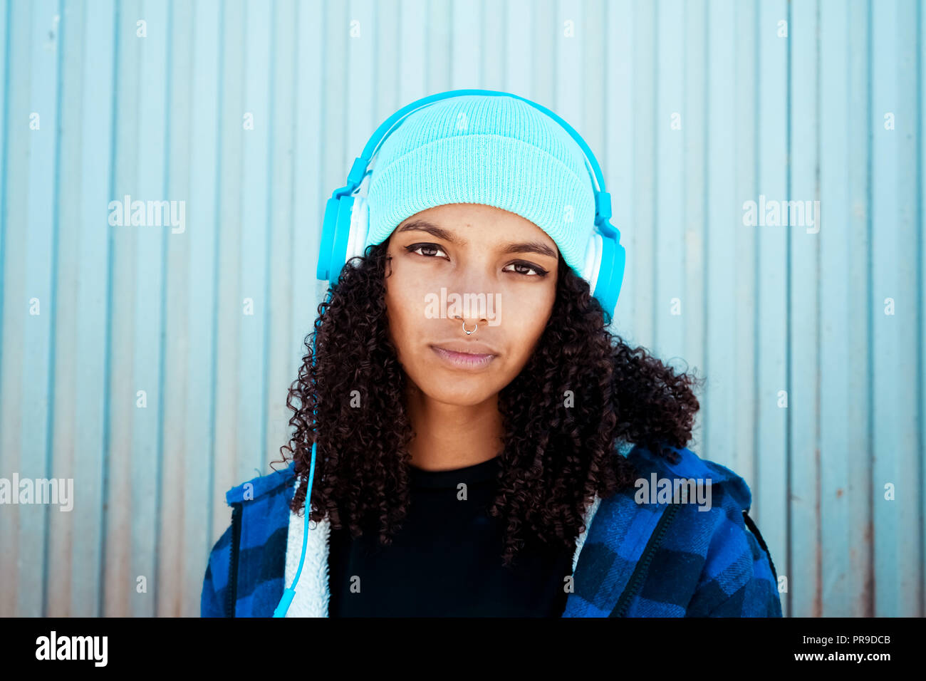 Junge Teenager Frau Musik vor einer blauen Wand Stockfoto