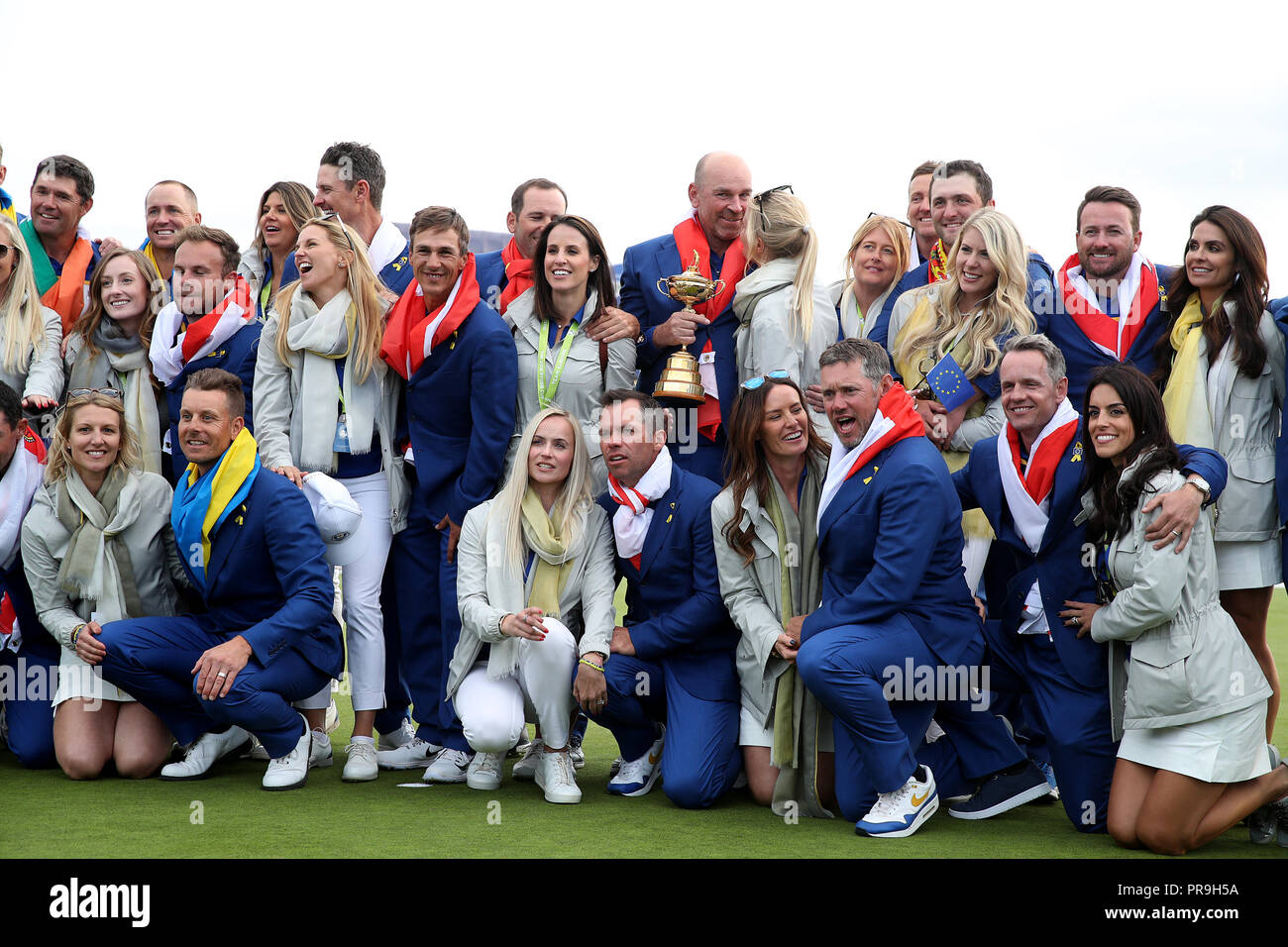 Team Europa Kapitän Thomas Bjorn feiert mit dem Ryder Cup Trophäe neben Spieler und deren Frauen und Freundinnen an Tag drei des Ryder Cup bei Le Golf National, Saint-Quentin-en-Yvelines, Paris. Stockfoto