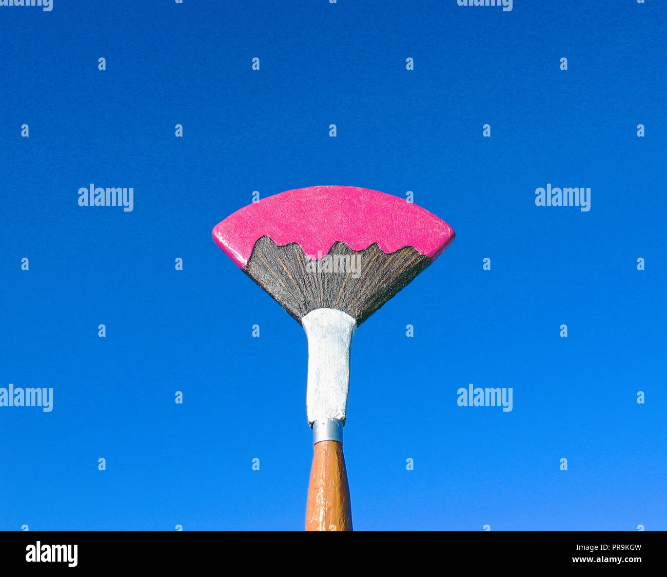 Ein riesiges Schild in der Form eines Künstlers Pinsel, gegen einen klaren blauen Himmel, erzeugt einen wunderbaren Hintergrund. Stockfoto