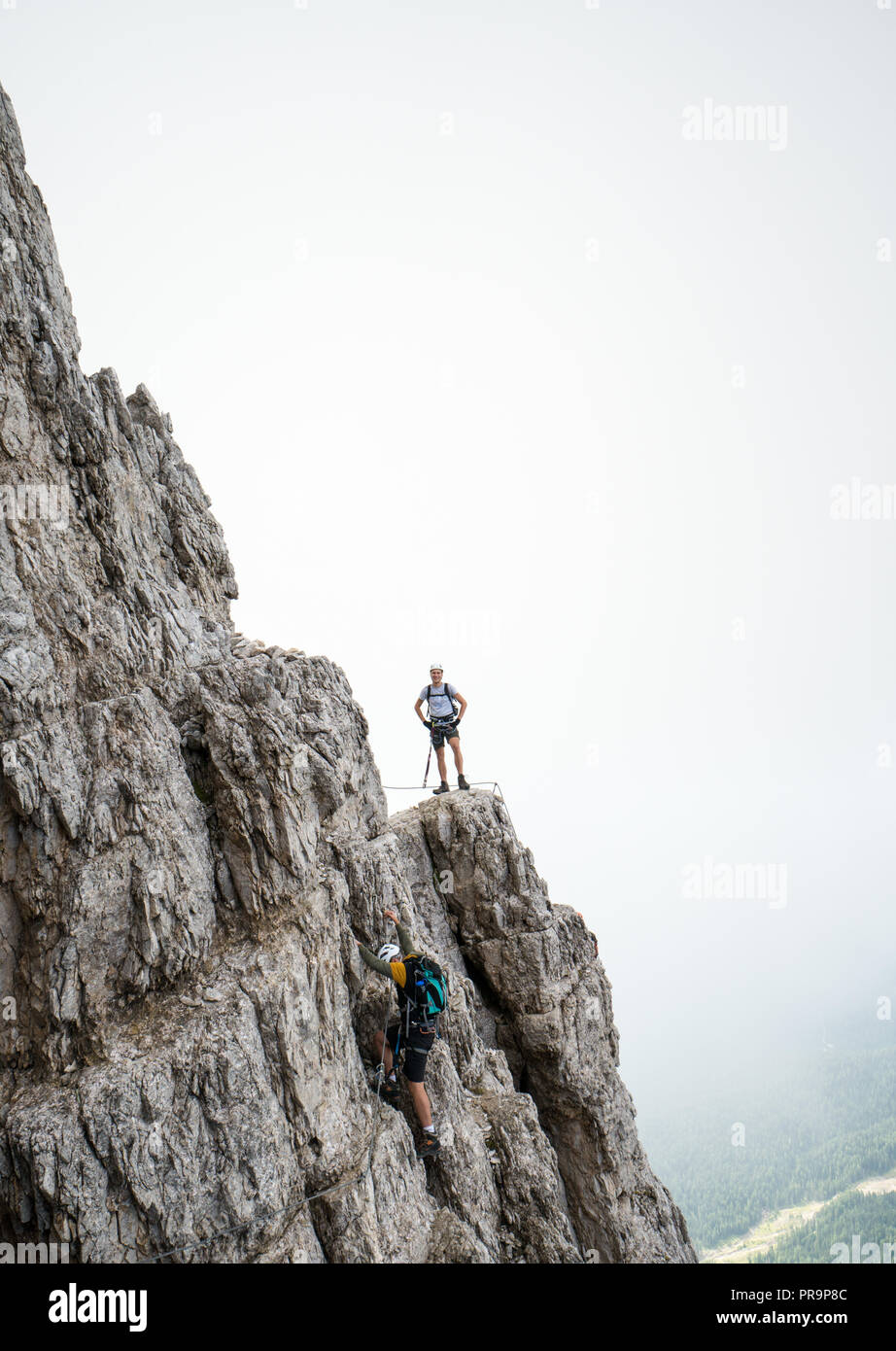 Zwei junge attraktive männliche Bergsteiger auf sehr exponierten Klettersteig in Alta Badia in den Dolomiten Stockfoto