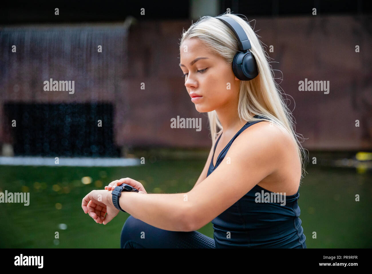 Sportliche Läuferin Musik hören über Kopfhörer, während Sie S Stockfoto