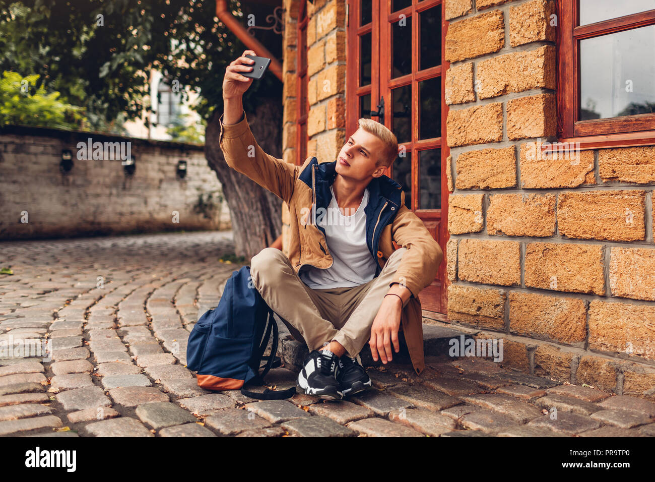 Student mit Rucksack nehmen selfie im Park können Sie über das Telefon auf Odessa Museum Gebiet. Guy Kühlen Stockfoto
