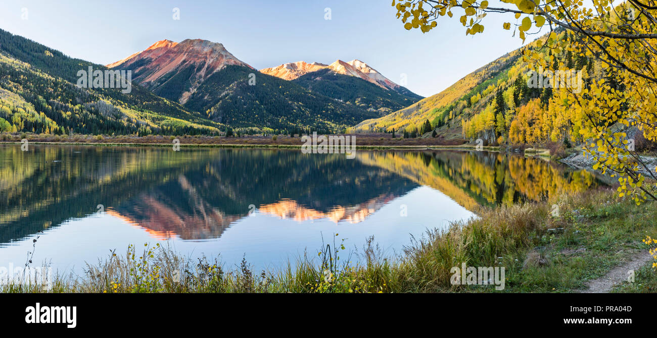 Die roten Berge und goldene Espen auf Hayden Berg spiegelt sich in Crystal Lake in den Uncompahgre National Forest im Süden von Ouray, Colorado. (Panora Stockfoto
