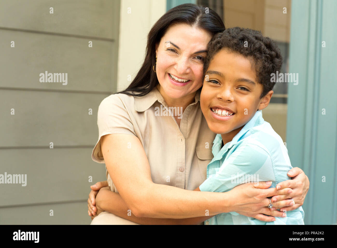 Glücklich lächelnd Hispnaic Mutter und ihr Sohn umarmen. Stockfoto
