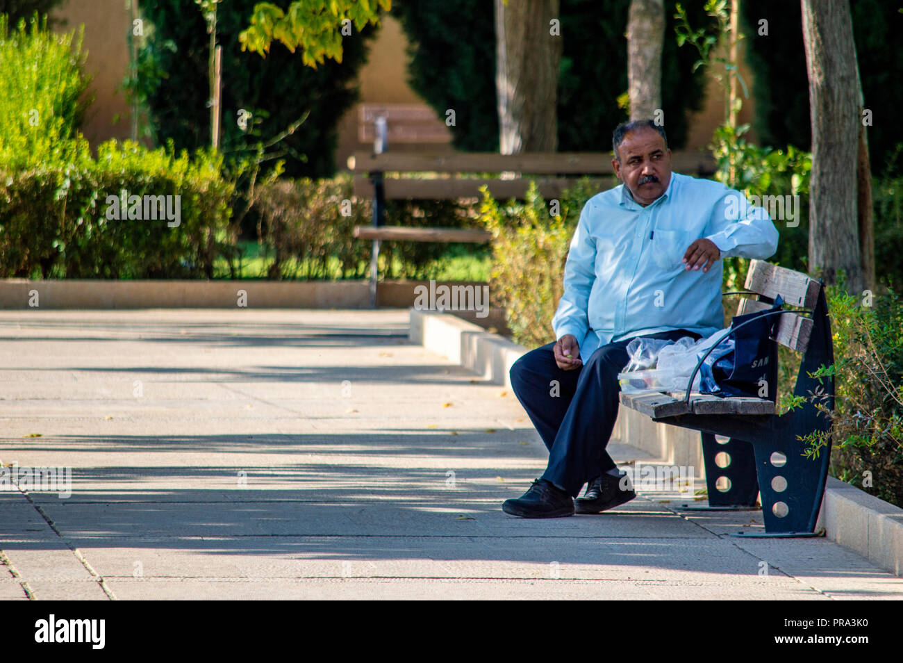 Ein Mann saß auf einer Bank in Schiraz, Iran Stockfoto