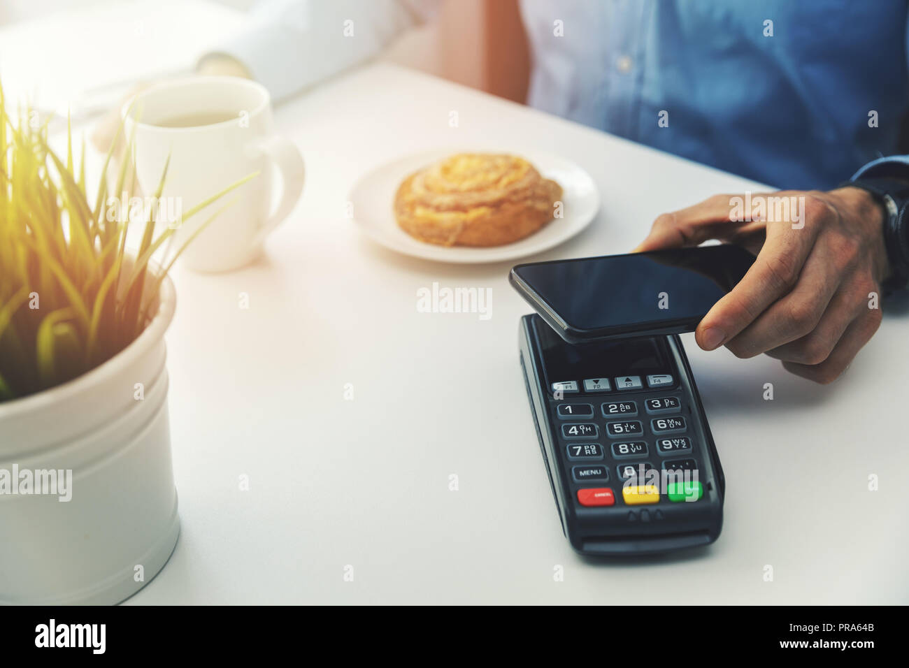 Nfc-Zahlung mit Handy im Cafe Stockfoto