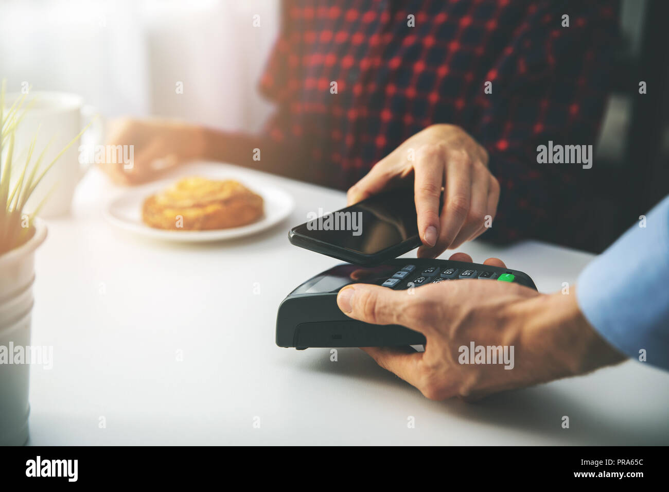 Kontaktloses Bezahlen - Frau Zahlung Rechnung mit Smartphone im Cafe Stockfoto