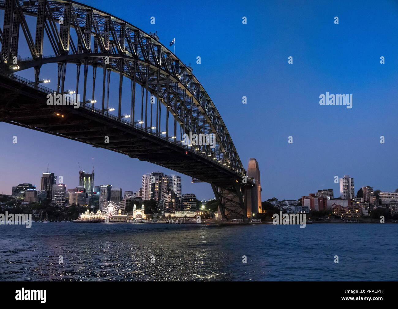 Blick auf Sydney Harbour Bridge nach Sonnenuntergang an der blauen Stunde mit Luna Park im Hintergrund genommen Stockfoto