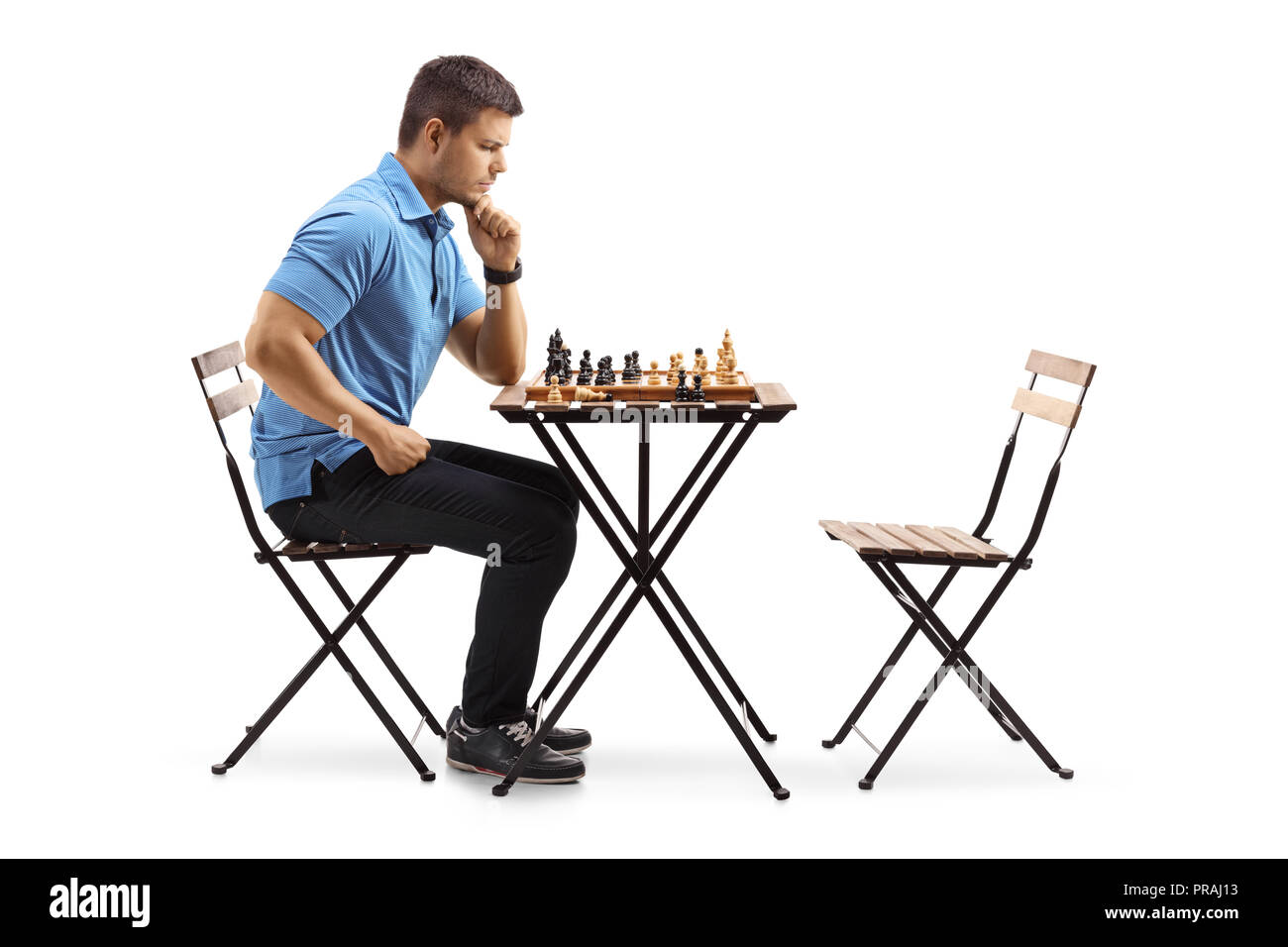 Nachdenklicher junger Mann an einem Tisch in ein Schachbrett, auf weißem Hintergrund suchen sitzt Stockfoto