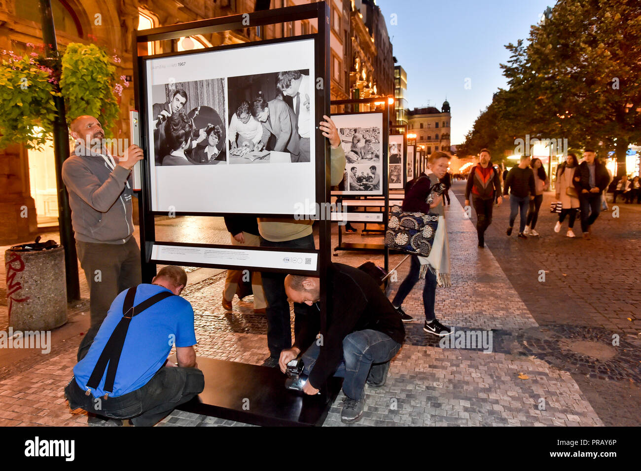 Prag, Tschechische Republik. 30 Sep, 2018. Editor-in-chief des CTK Photobank Petr Mlch, Links, passt eine Wanderausstellung von Fotos aus den Archiven der tschechischen Nachrichtenagentur (CTK), bedeutende Momente der 100 Jahre seit der Gründung der Tschechoslowakei 1918 an Na Prikopech Fußgängerzone in Prag, Tschechische Republik, 30. September 2018. Quelle: Vit Simanek/CTK Photo/Alamy leben Nachrichten Stockfoto